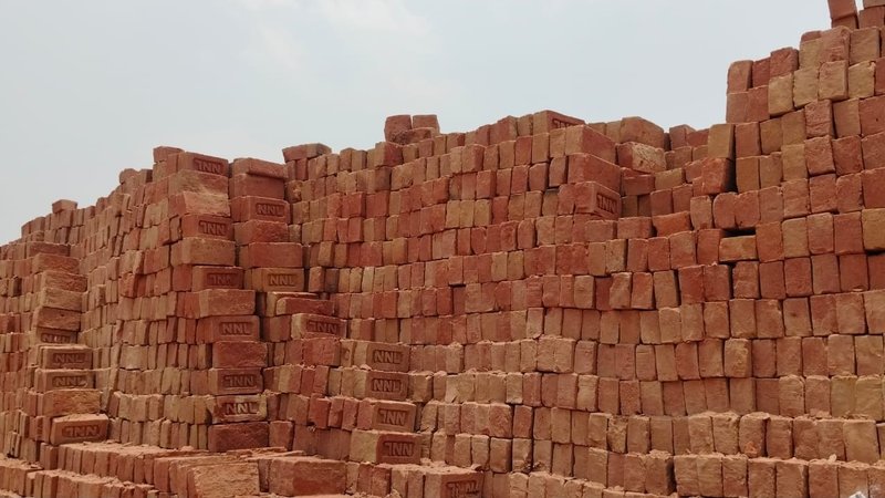 पक्की लाल ईंट के करीने से लगे ढेर — stacks of fired NNL red clay bricks